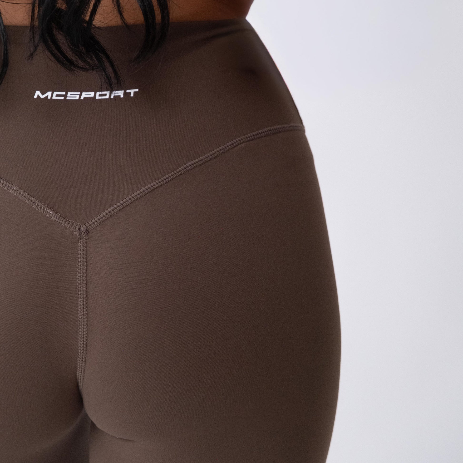 Leggings sportivi marroni da donna indossati a vita alta: tessuto elasticizzato, morbido e confortevole per fitness, yoga, pilates e allenamenti di ogni intensità.