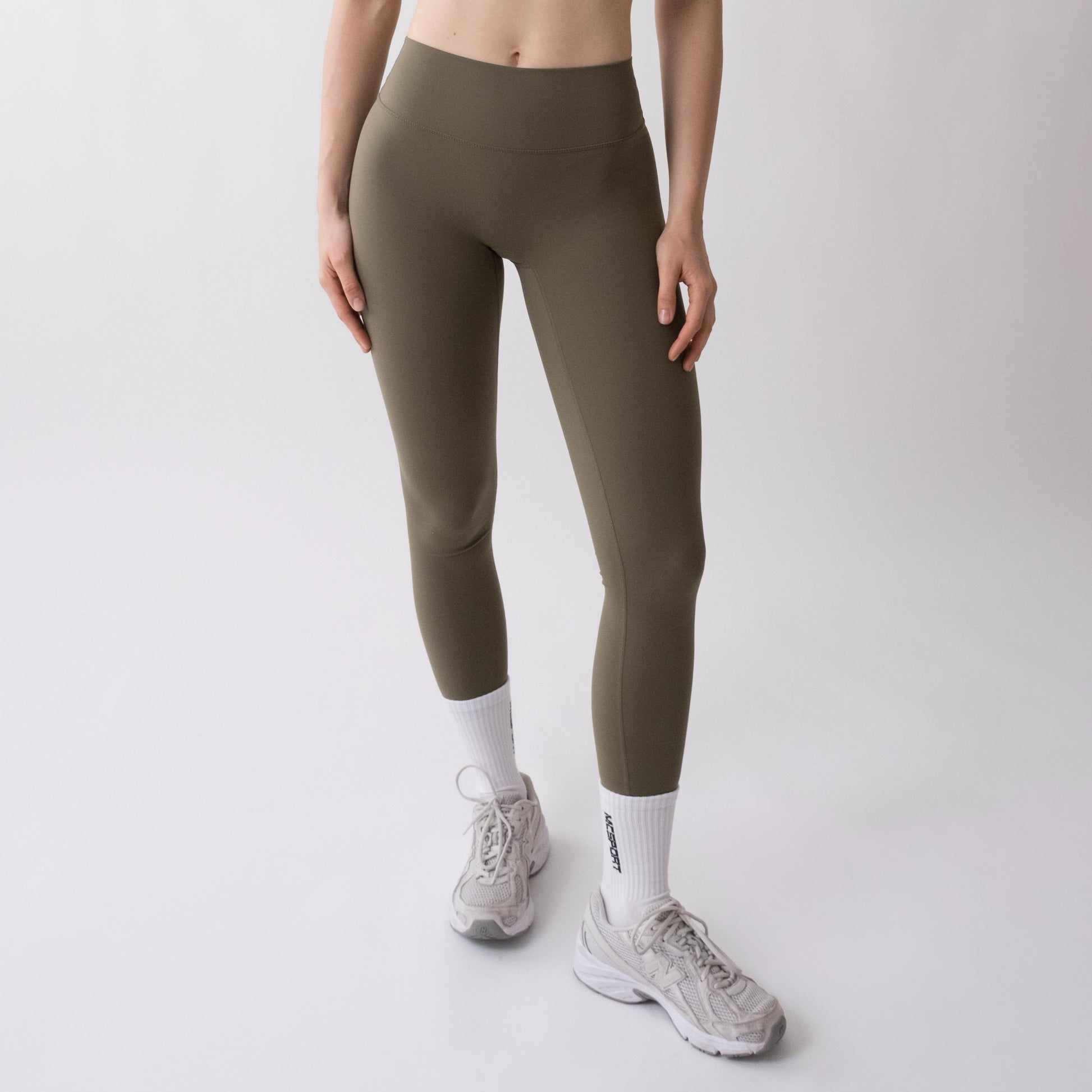 Leggings sportivi verdi da donna indossati a vita alta: tessuto elasticizzato, morbido e confortevole per fitness, yoga, pilates e allenamenti di ogni intensità.