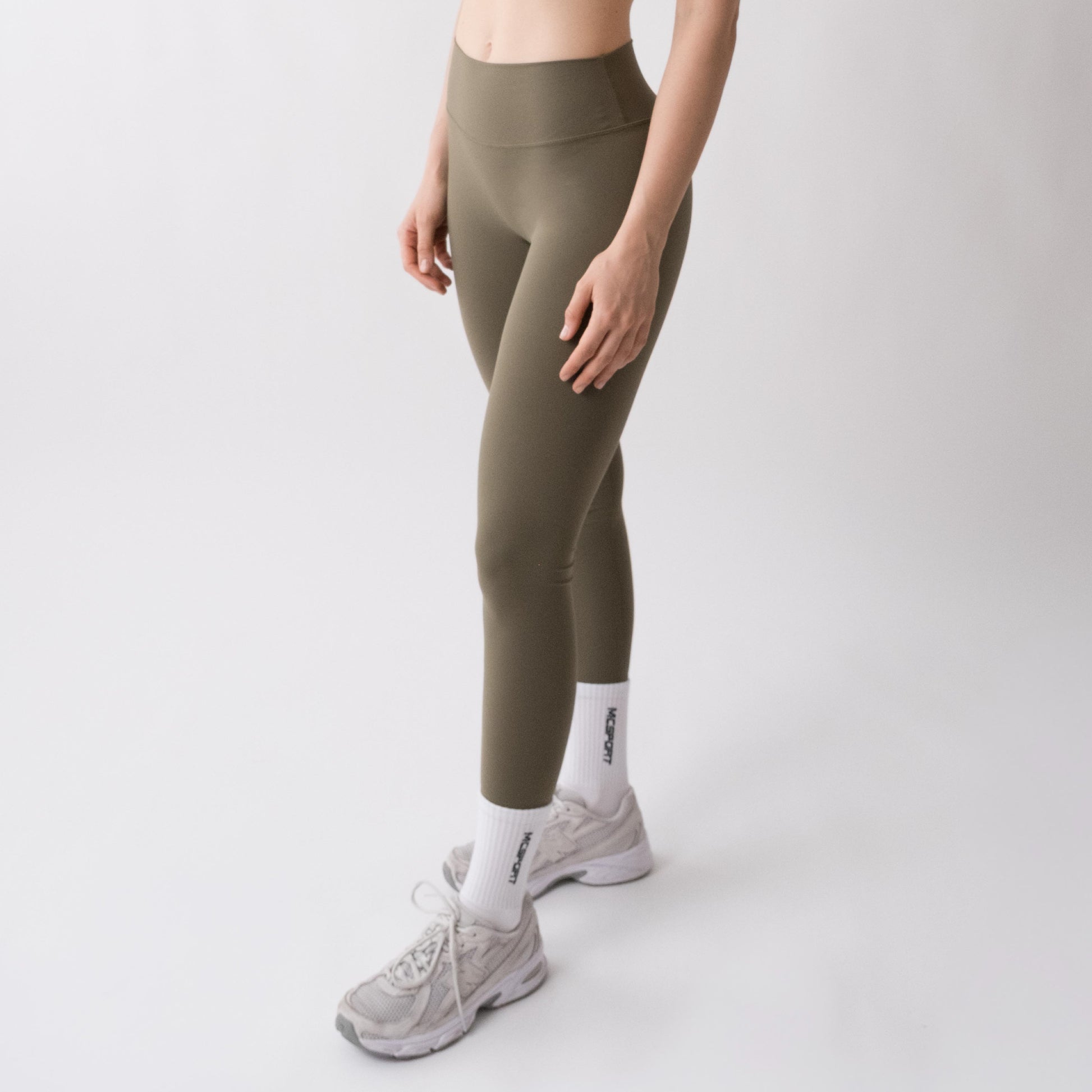 Leggings sportivi verdi da donna indossati a vita alta: tessuto elasticizzato, morbido e confortevole per fitness, yoga, pilates e allenamenti di ogni intensità.