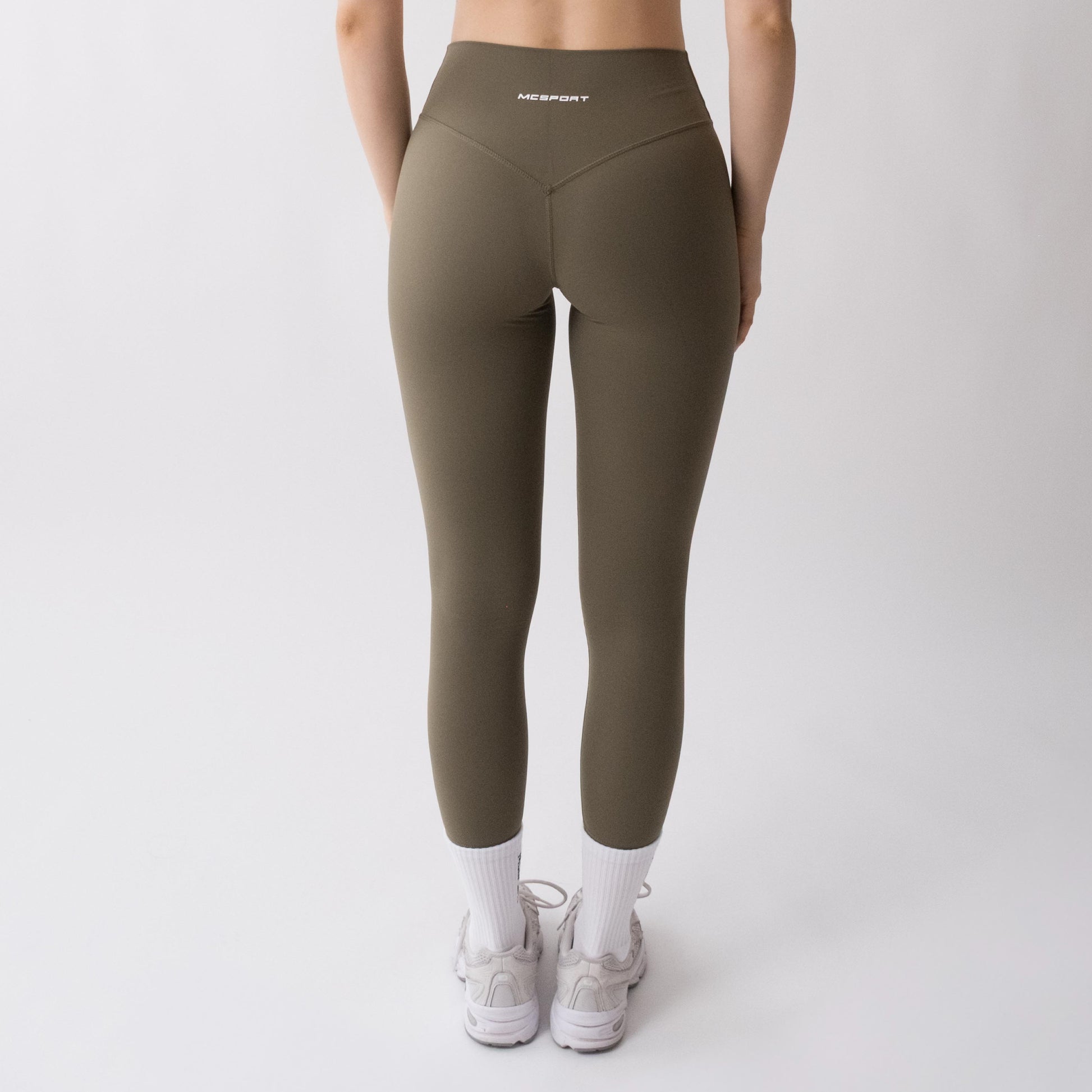 Leggings sportivi verdi da donna indossati a vita alta: tessuto elasticizzato, morbido e confortevole per fitness, yoga, pilates e allenamenti di ogni intensità.