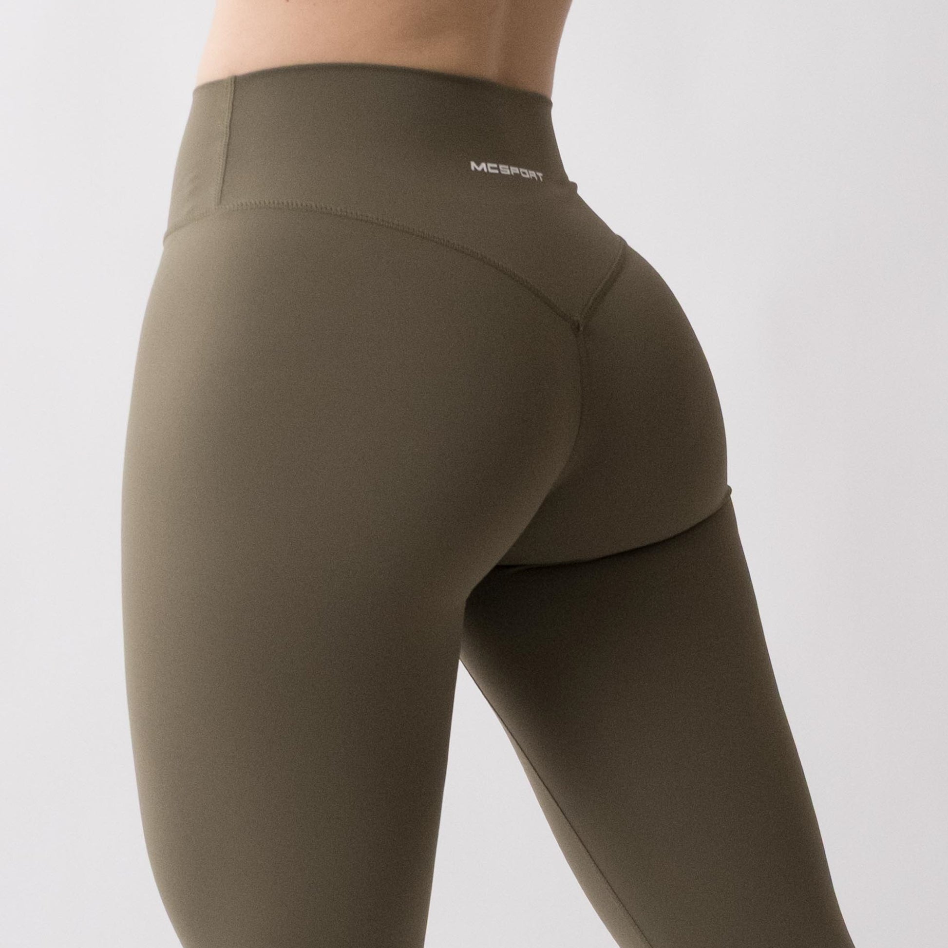 Leggings sportivi verdi da donna indossati a vita alta: tessuto elasticizzato, morbido e confortevole per fitness, yoga, pilates e allenamenti di ogni intensità.