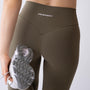 Leggings sportivi verdi da donna indossati a vita alta: tessuto elasticizzato, morbido e confortevole per fitness, yoga, pilates e allenamenti di ogni intensità.