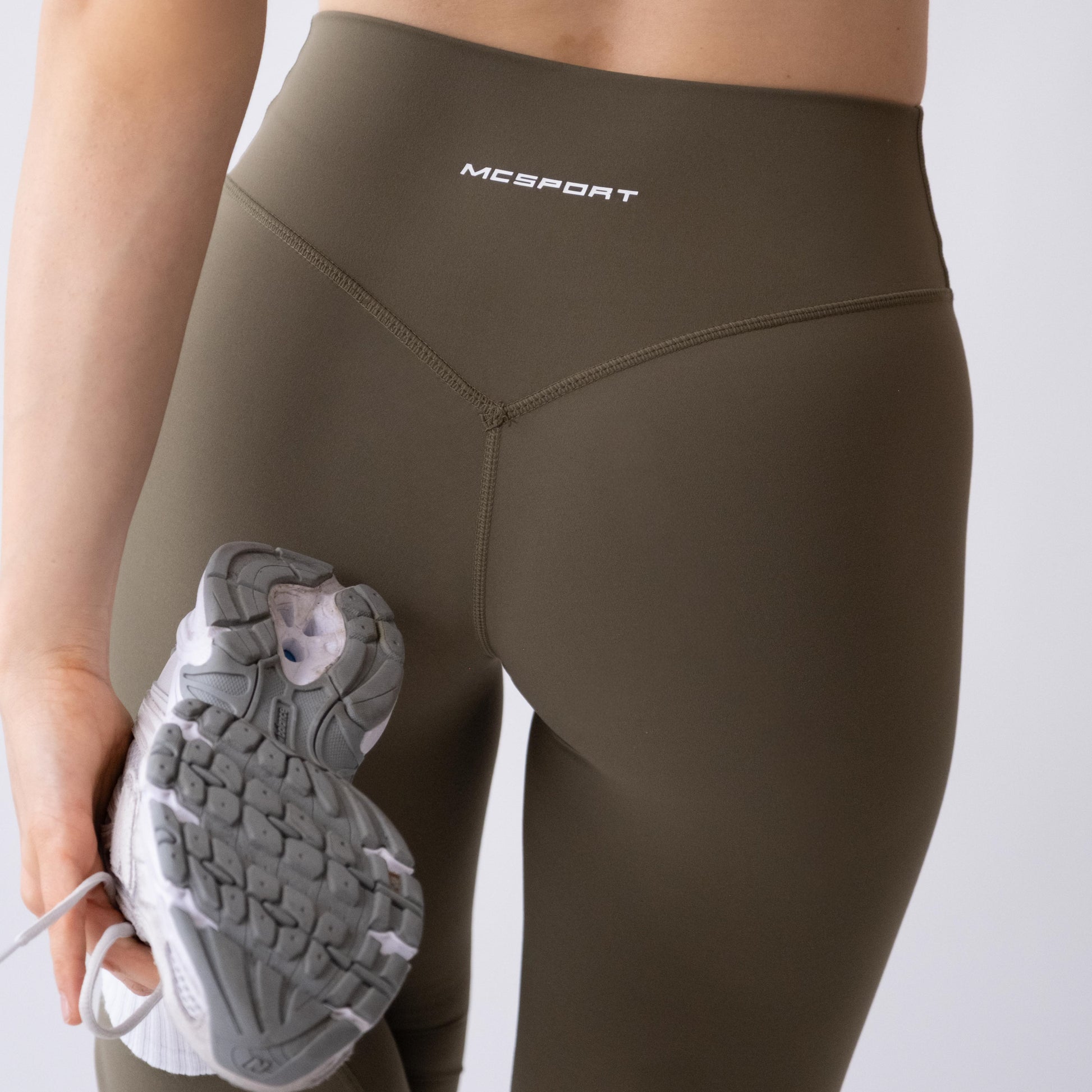 Leggings sportivi verdi da donna indossati a vita alta: tessuto elasticizzato, morbido e confortevole per fitness, yoga, pilates e allenamenti di ogni intensità.