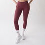 Leggings sportivi rossi da donna indossati a vita alta: tessuto elasticizzato, morbido e confortevole per fitness, yoga, pilates e allenamenti di ogni intensità.