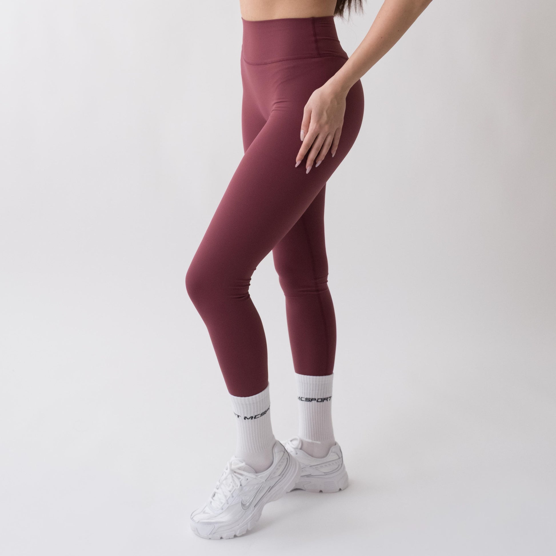 Leggings sportivi rossi da donna indossati a vita alta: tessuto elasticizzato, morbido e confortevole per fitness, yoga, pilates e allenamenti di ogni intensità.