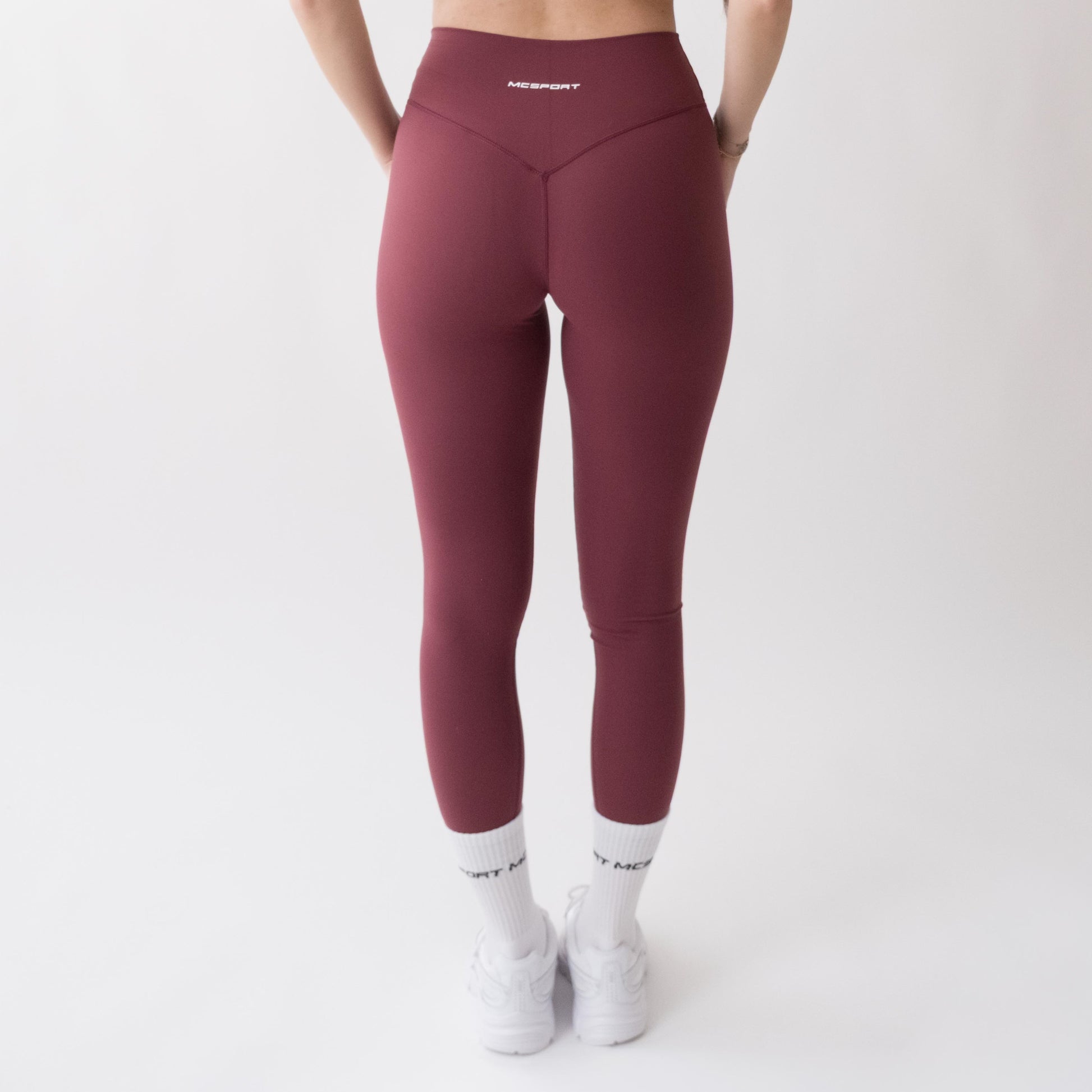 Leggings sportivi rossi da donna indossati a vita alta: tessuto elasticizzato, morbido e confortevole per fitness, yoga, pilates e allenamenti di ogni intensità.