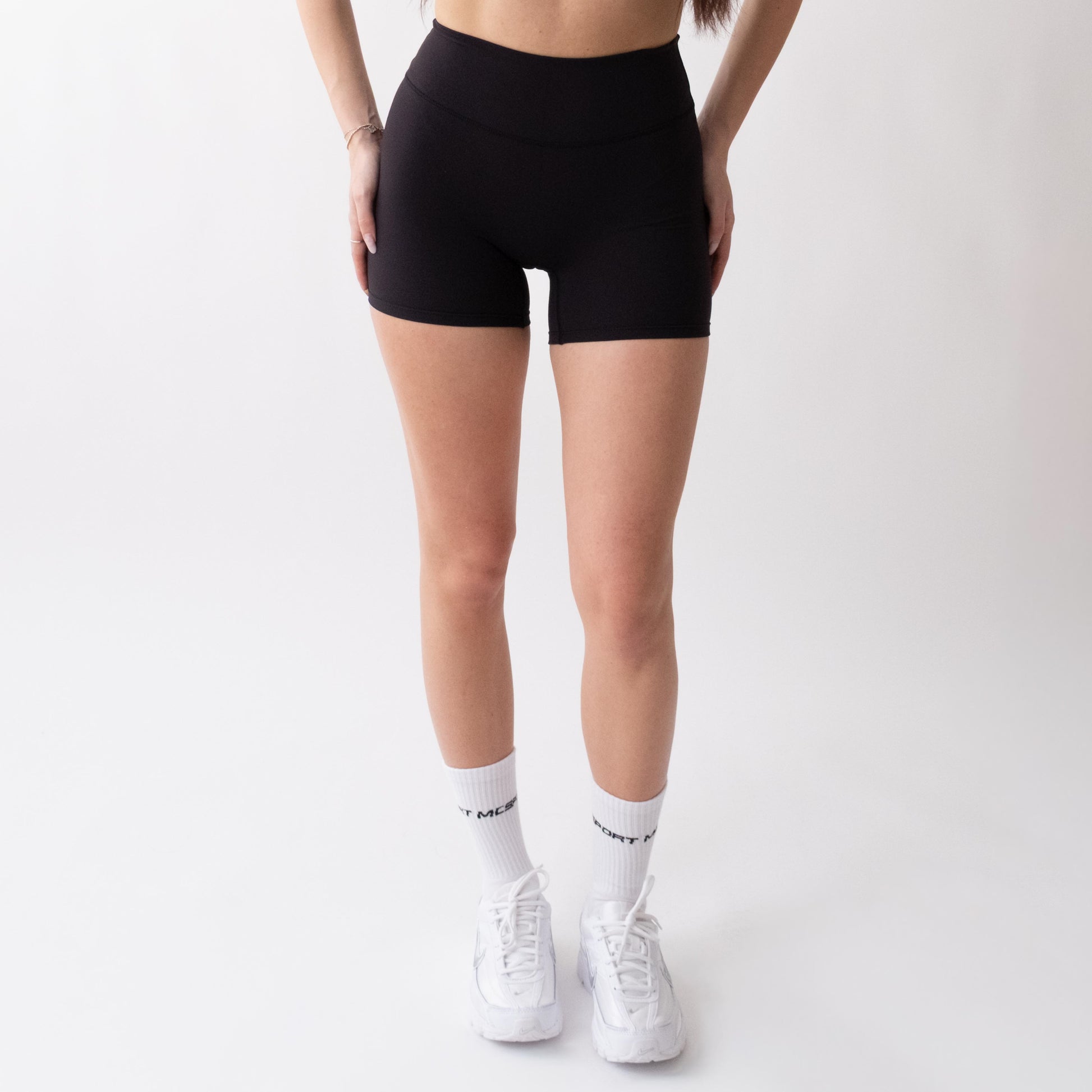 Shorts sportivi neri da donna indossati a vita alta: tessuto elasticizzato, morbido e confortevole, perfetti per fitness, yoga, pilates e allenamenti di ogni intensità.