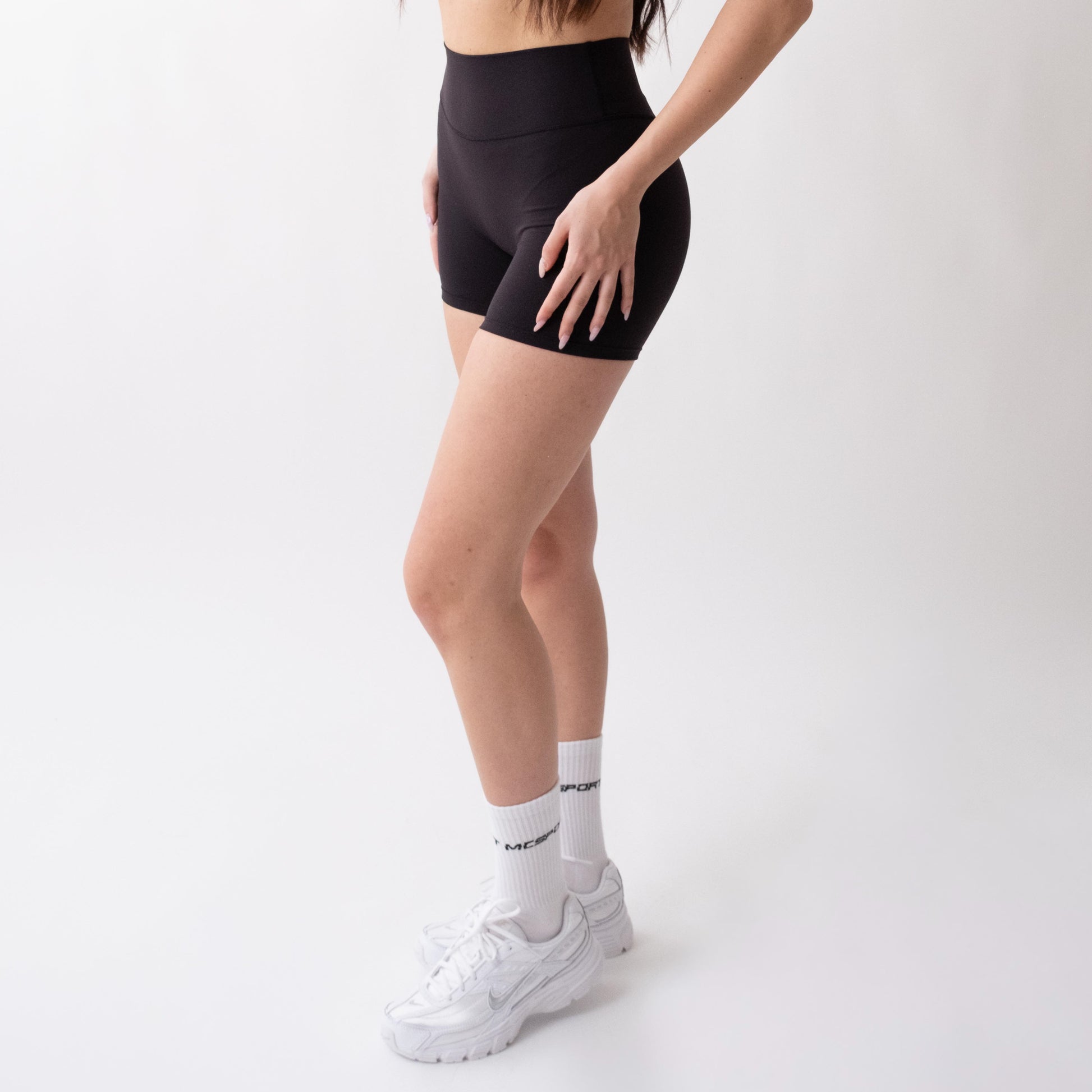 Shorts sportivi neri da donna indossati a vita alta: tessuto elasticizzato, morbido e confortevole, perfetti per fitness, yoga, pilates e allenamenti di ogni intensità.