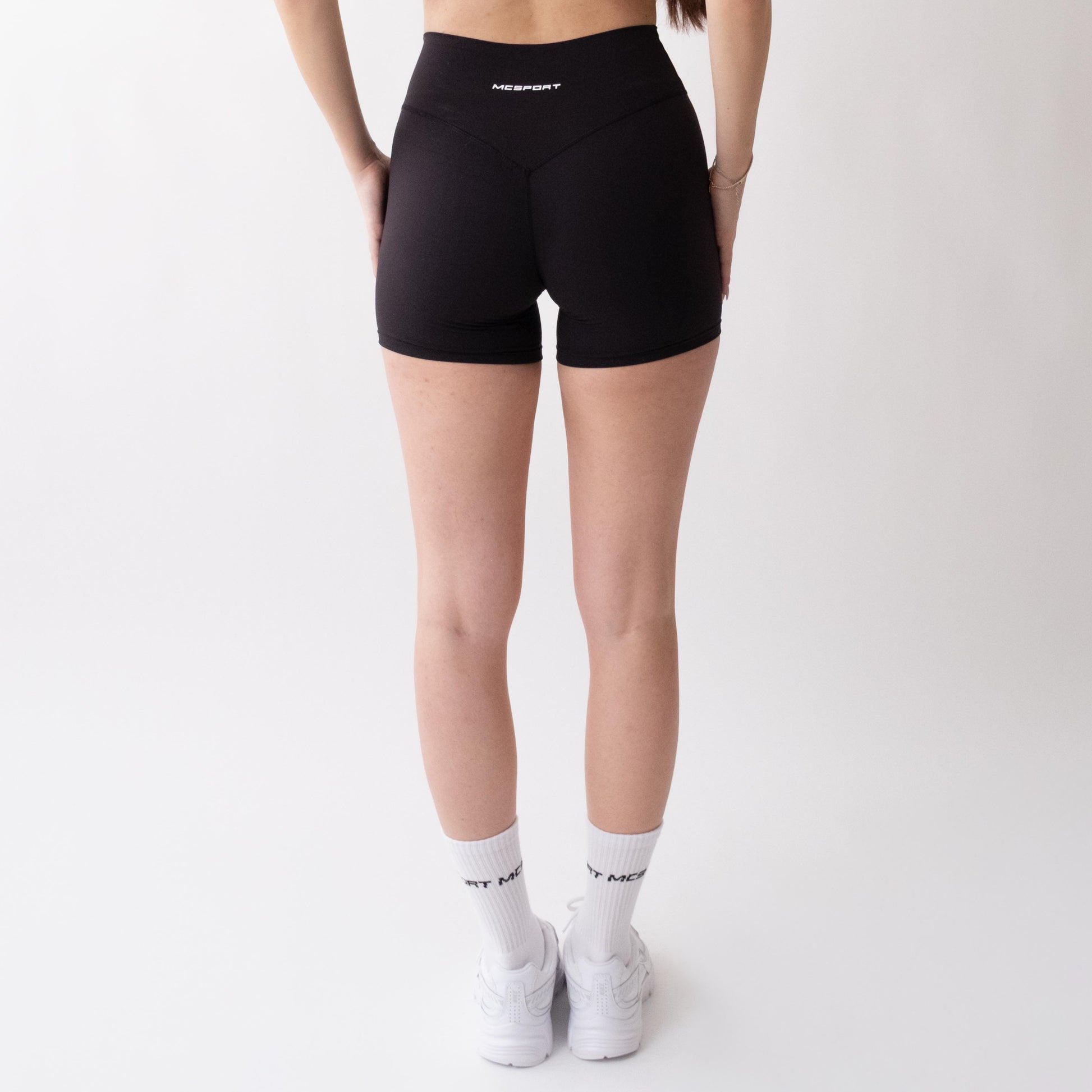 Shorts sportivi neri da donna indossati a vita alta: tessuto elasticizzato, morbido e confortevole, perfetti per fitness, yoga, pilates e allenamenti di ogni intensità.