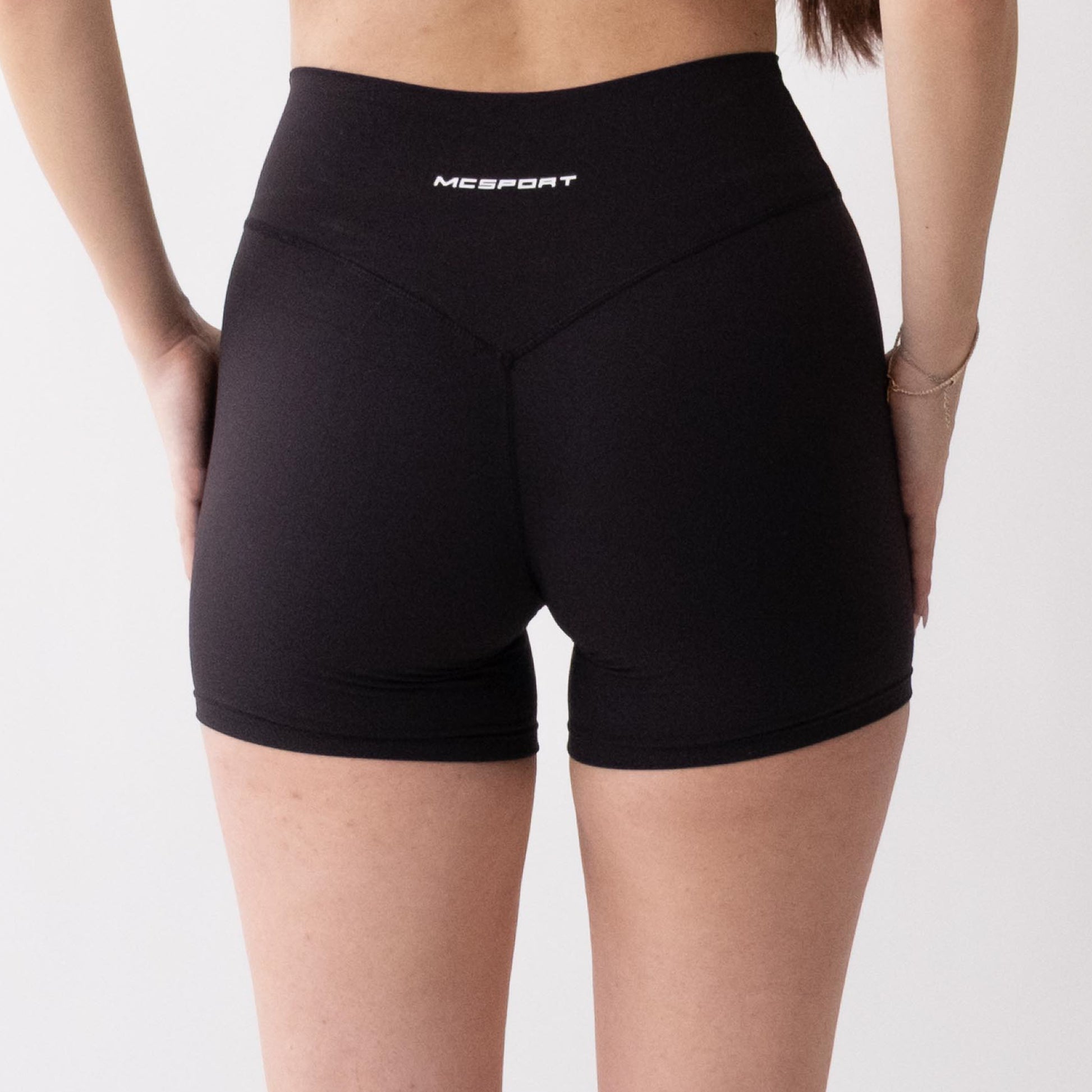 Shorts sportivi neri da donna indossati a vita alta: tessuto elasticizzato, morbido e confortevole, perfetti per fitness, yoga, pilates e allenamenti di ogni intensità.