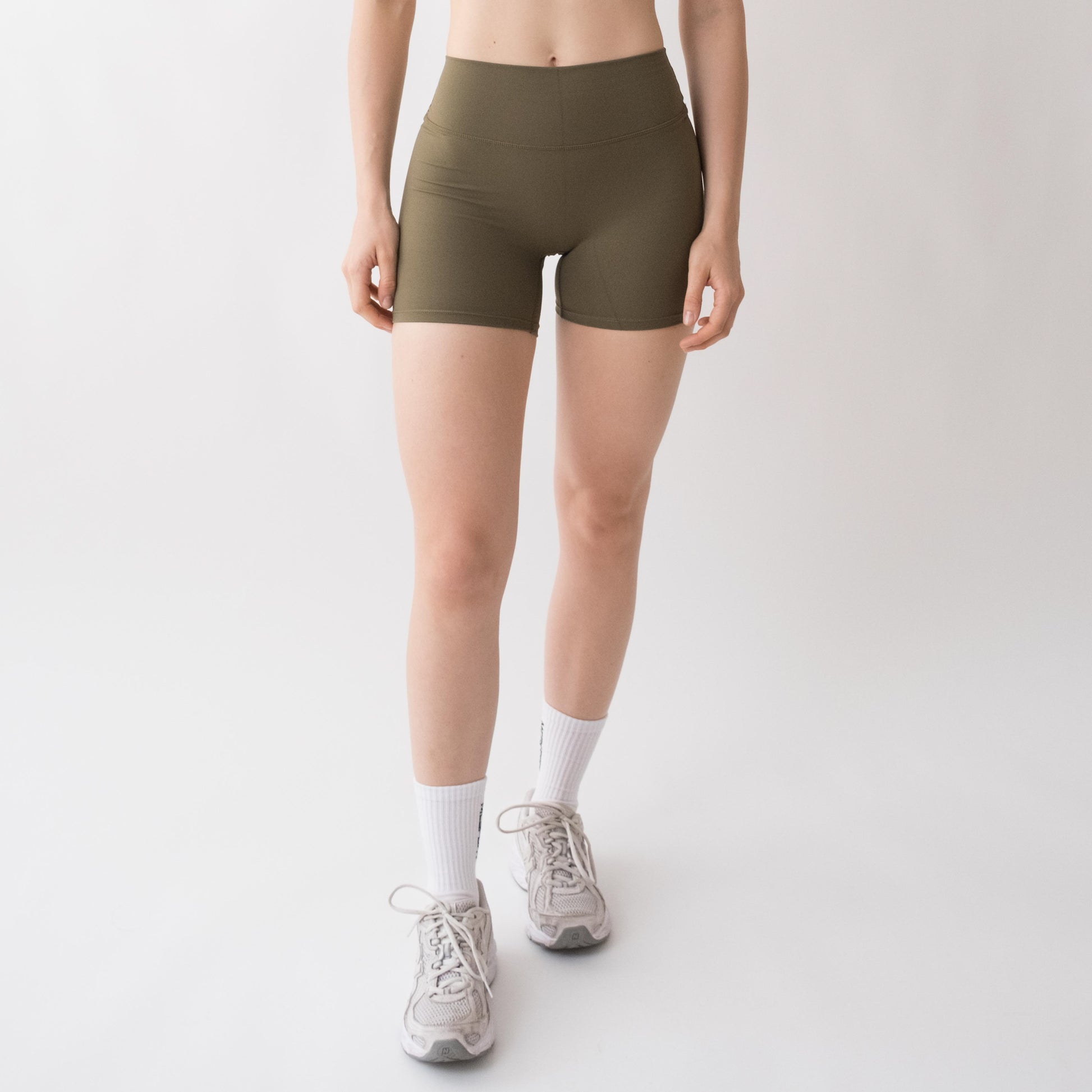 Shorts sportivi verdi da donna indossati a vita alta: tessuto elasticizzato, morbido e confortevole, perfetti per fitness, yoga, pilates e allenamenti di ogni intensità.