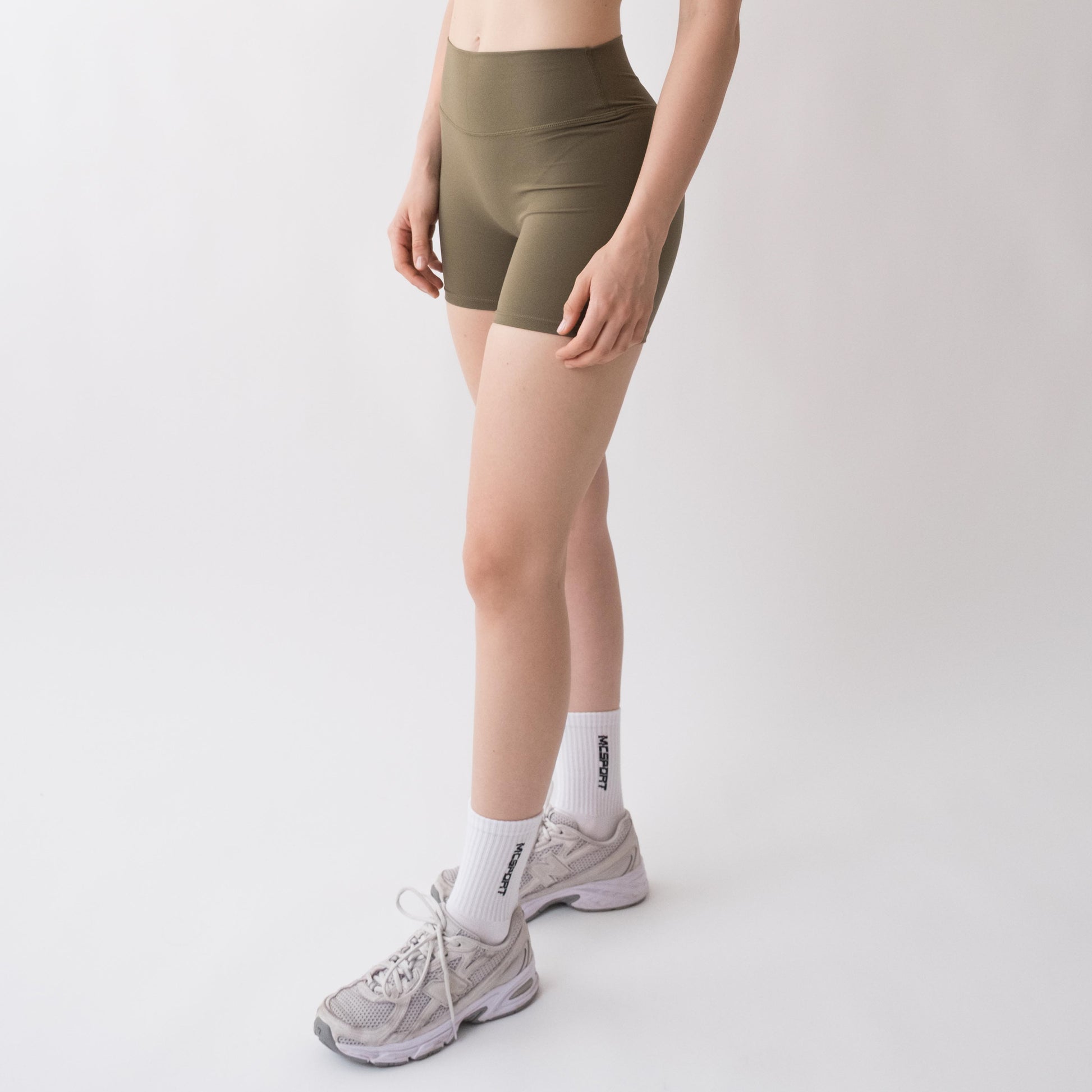 Shorts sportivi verdi da donna indossati a vita alta: tessuto elasticizzato, morbido e confortevole, perfetti per fitness, yoga, pilates e allenamenti di ogni intensità.