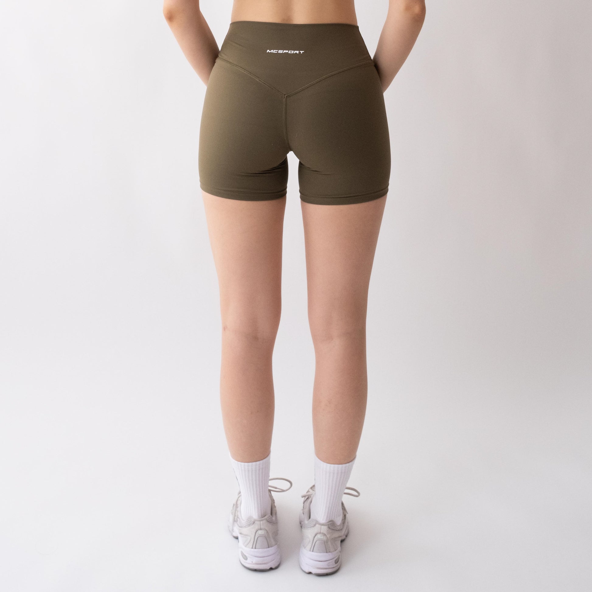 Shorts sportivi verdi da donna indossati a vita alta: tessuto elasticizzato, morbido e confortevole, perfetti per fitness, yoga, pilates e allenamenti di ogni intensità.