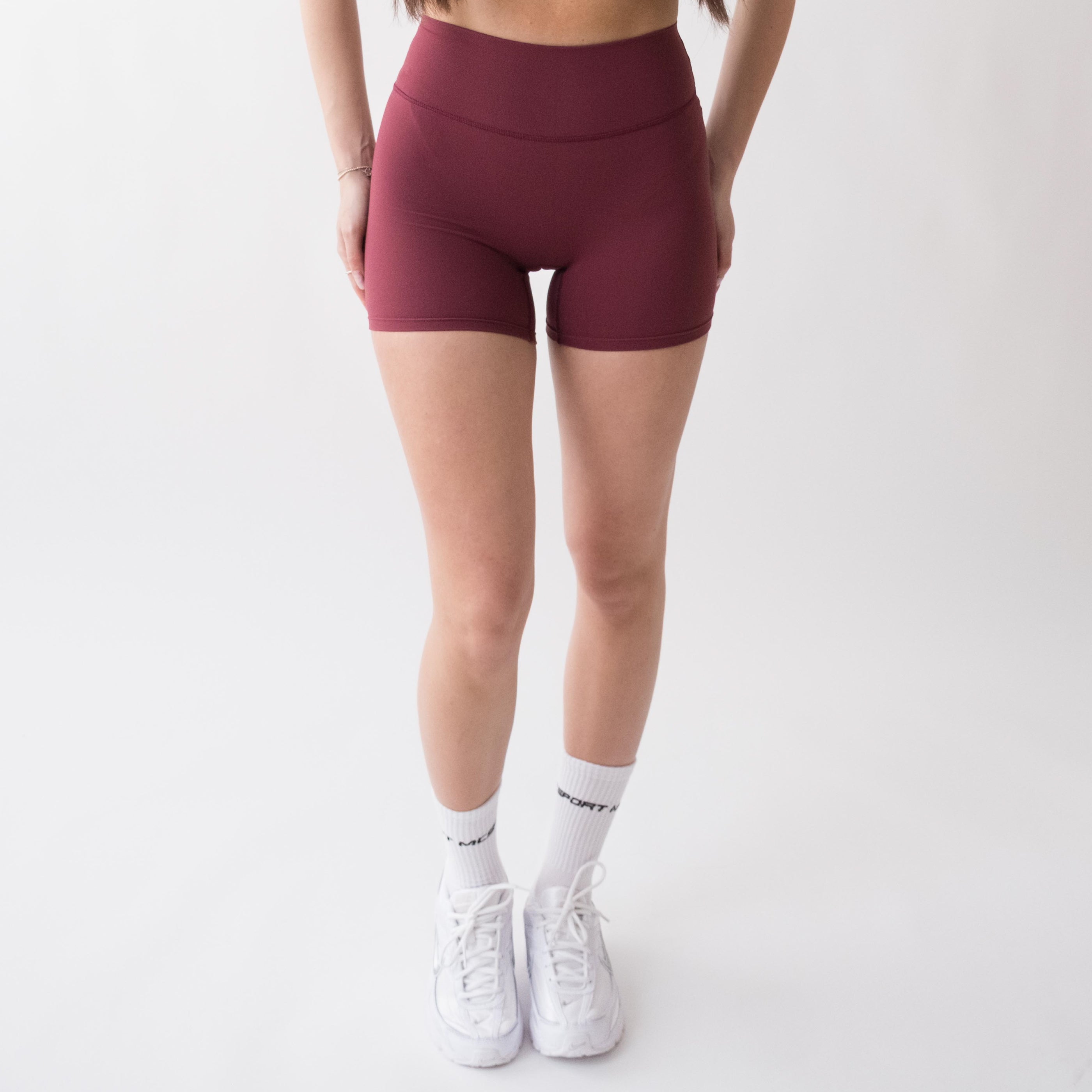Shorts sportivi rossi da donna indossati a vita alta: tessuto elasticizzato, morbido e confortevole, perfetti per fitness, yoga, pilates e allenamenti di ogni intensità.