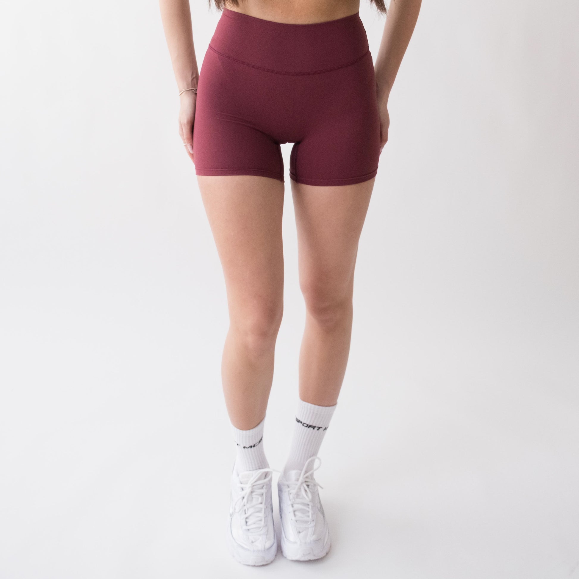 Shorts sportivi rossi da donna indossati a vita alta: tessuto elasticizzato, morbido e confortevole, perfetti per fitness, yoga, pilates e allenamenti di ogni intensità.