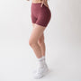 Shorts sportivi rossi da donna indossati a vita alta: tessuto elasticizzato, morbido e confortevole, perfetti per fitness, yoga, pilates e allenamenti di ogni intensità.