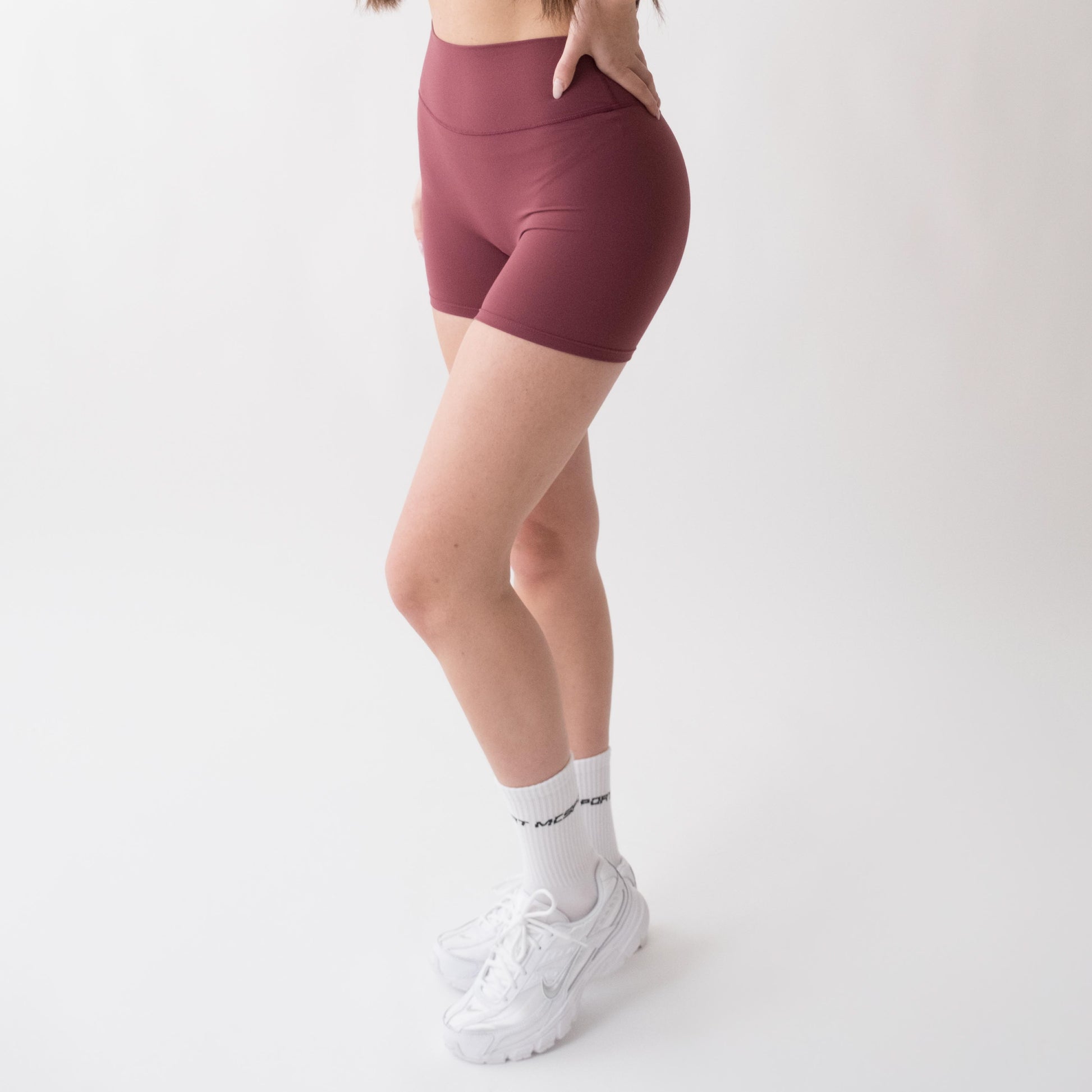 Shorts sportivi rossi da donna indossati a vita alta: tessuto elasticizzato, morbido e confortevole, perfetti per fitness, yoga, pilates e allenamenti di ogni intensità.