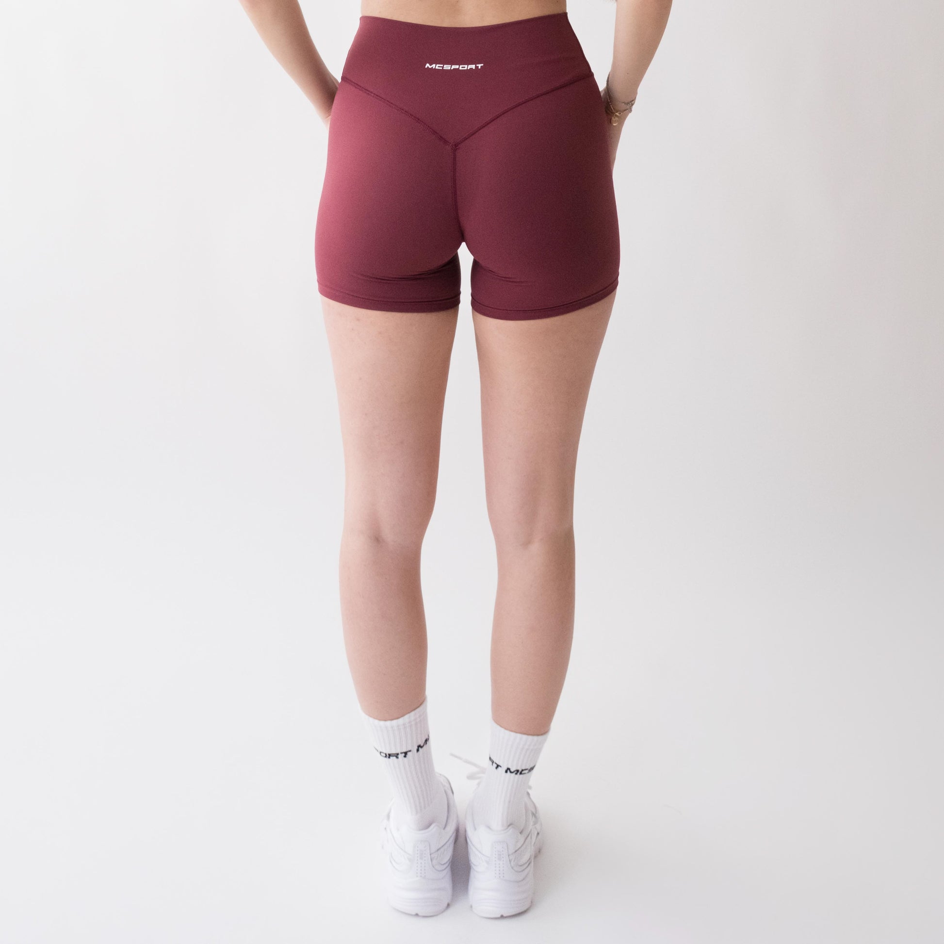 Shorts sportivi rossi da donna indossati a vita alta: tessuto elasticizzato, morbido e confortevole, perfetti per fitness, yoga, pilates e allenamenti di ogni intensità.