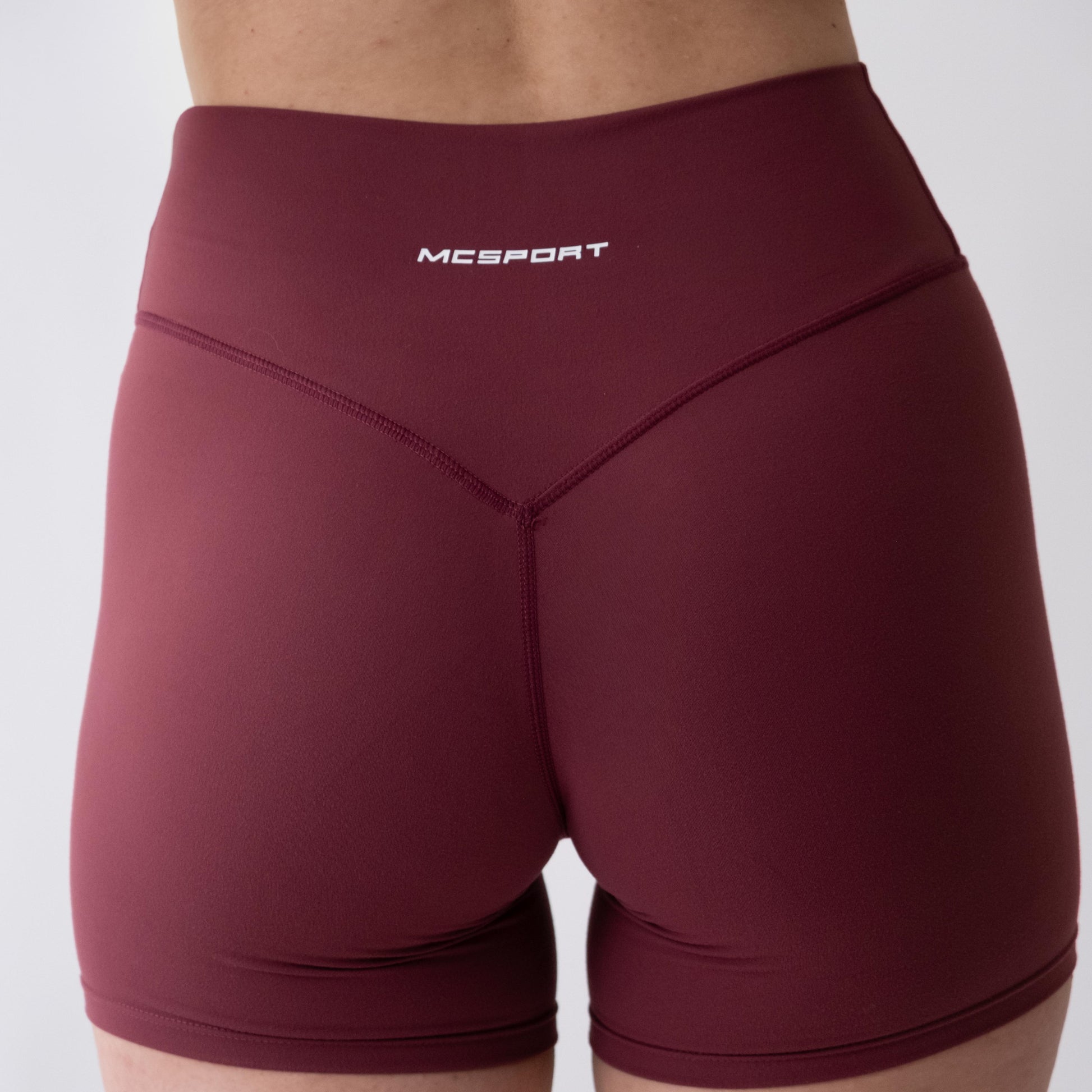 Shorts sportivi rossi da donna indossati a vita alta: tessuto elasticizzato, morbido e confortevole, perfetti per fitness, yoga, pilates e allenamenti di ogni intensità.