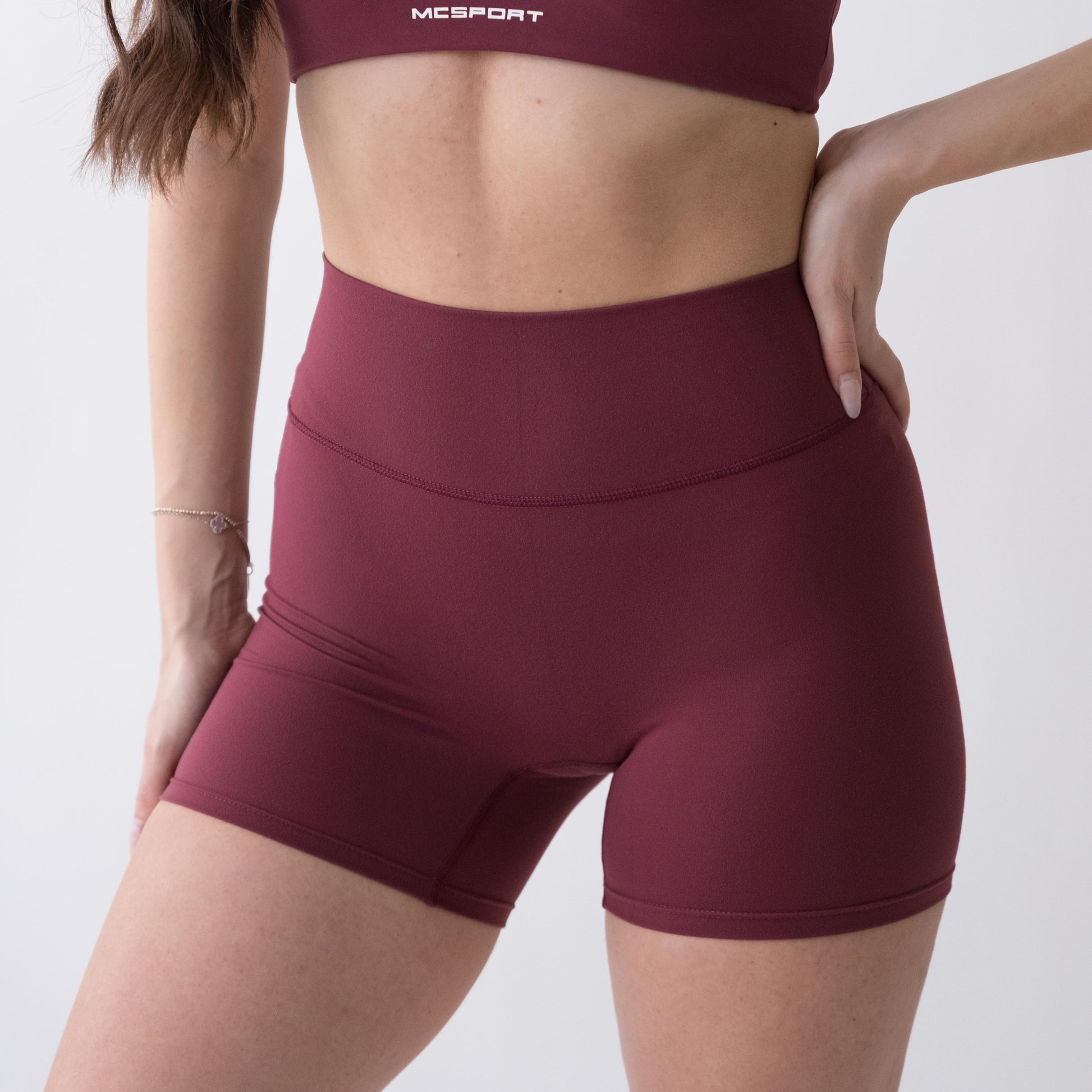 Shorts sportivi rossi da donna indossati a vita alta: tessuto elasticizzato, morbido e confortevole, perfetti per fitness, yoga, pilates e allenamenti di ogni intensità.