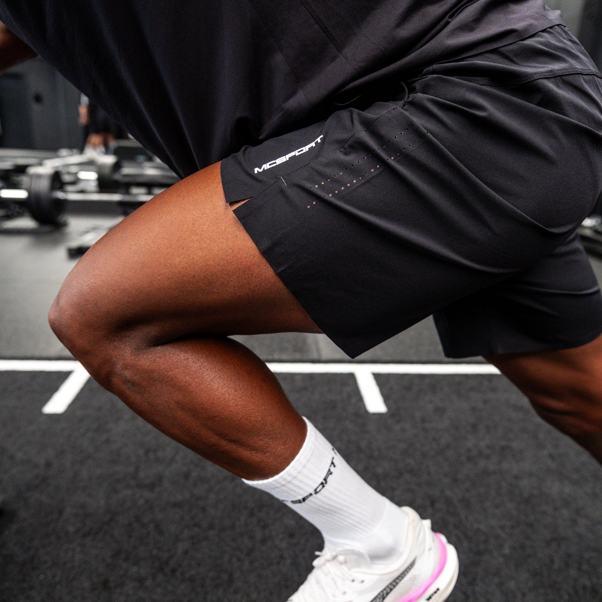 Pantaloncini neri sportivi da uomo indossati con tessuto 4-way stretch, ventilazione laser, tasca con zip e massimo comfort per ogni allenamento.