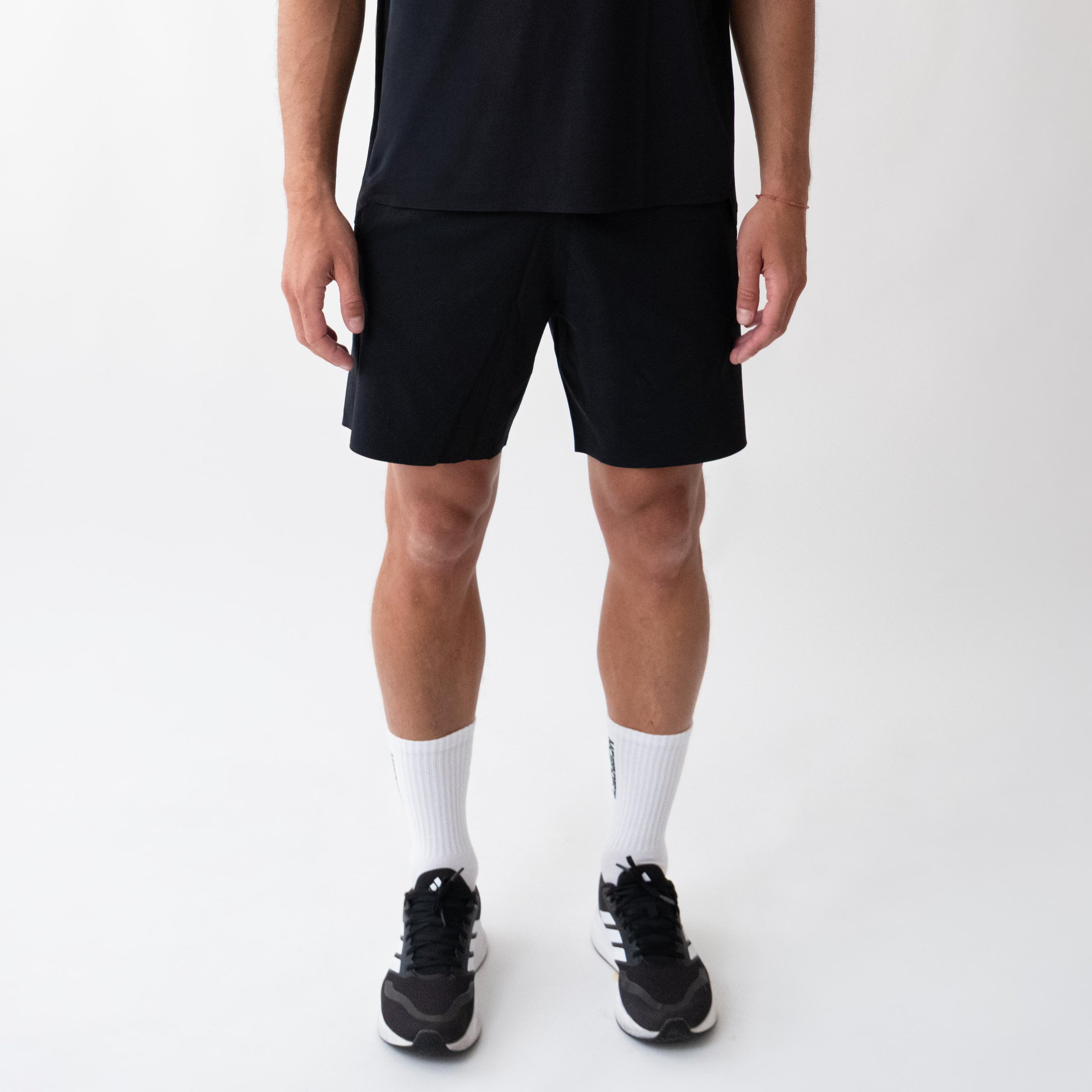 Pantaloncini neri sportivi da uomo indossati con tessuto 4-way stretch, ventilazione laser, tasca con zip e massimo comfort per ogni allenamento.