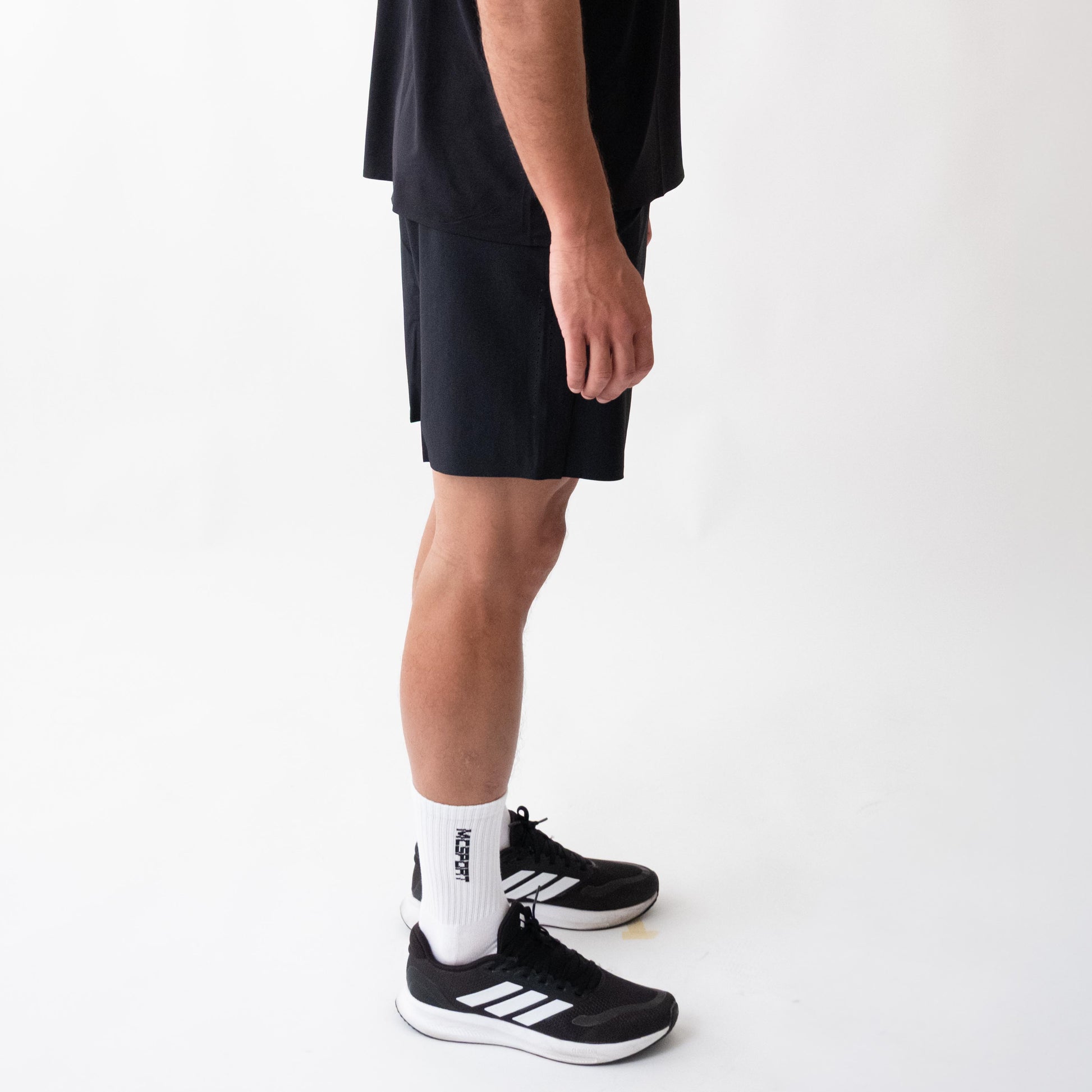 Pantaloncini neri sportivi da uomo indossati con tessuto 4-way stretch, ventilazione laser, tasca con zip e massimo comfort per ogni allenamento.